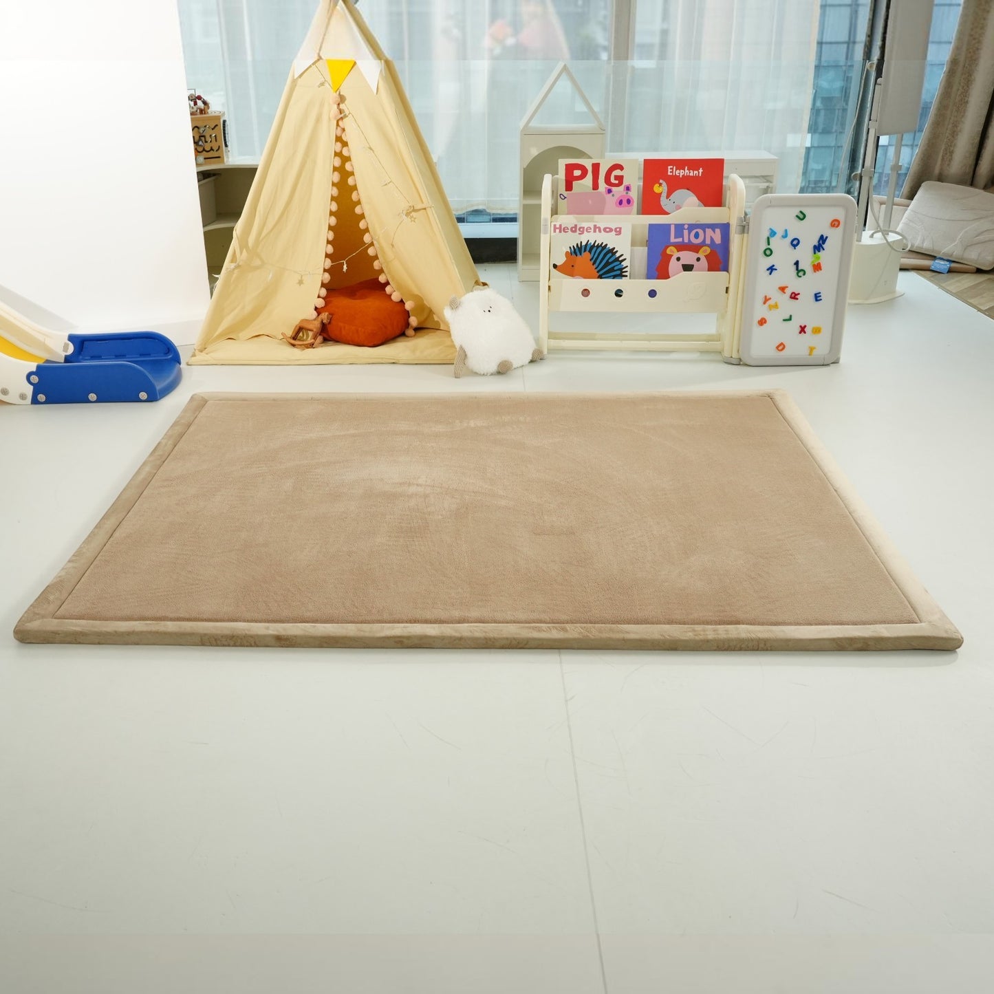  Реална снимка на бежов детски мемори килим GINGER HOME LOLLA, поставен в детска стая с играчки и мебели. 