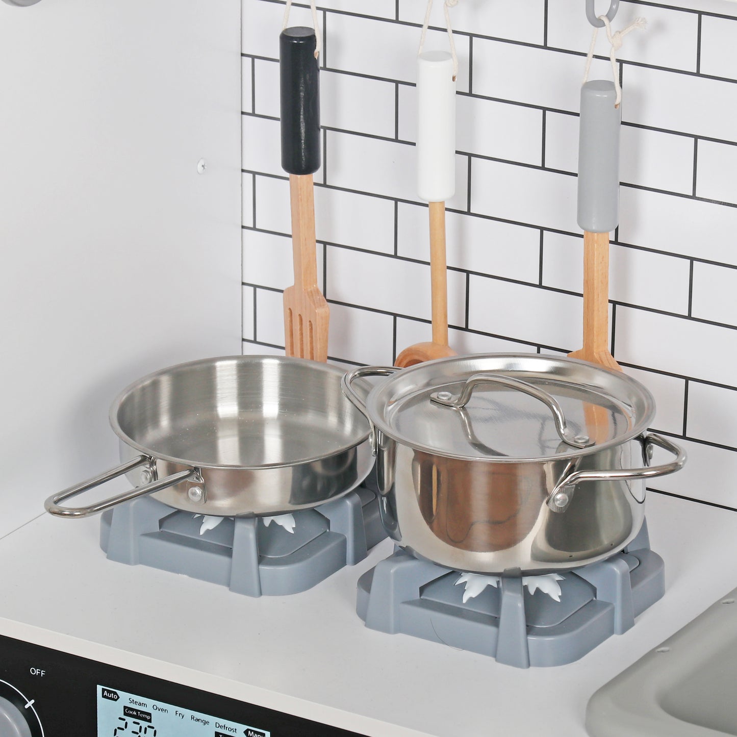 Детайл на детска кухня GINGER HOME с метална тенджера, тиган, котлони и дървени кухненски прибори